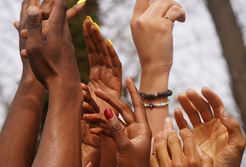 Many Black hands reach to the sky