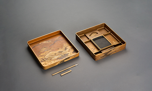 A square wooden box with ornate details and multiple compartments.