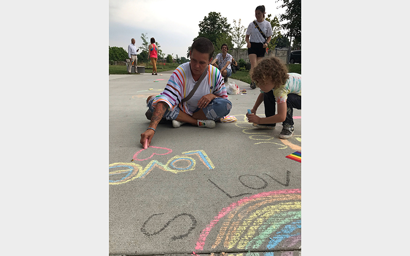 A parent and child draw with chalk