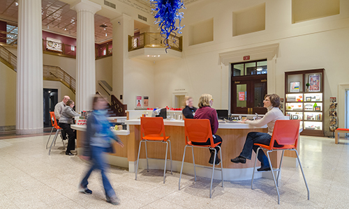 Visitors sit at the bar in the front lobby.