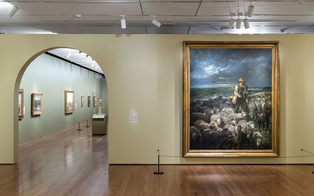 A massive painting of a shepherd on a wall beside an arched doorway