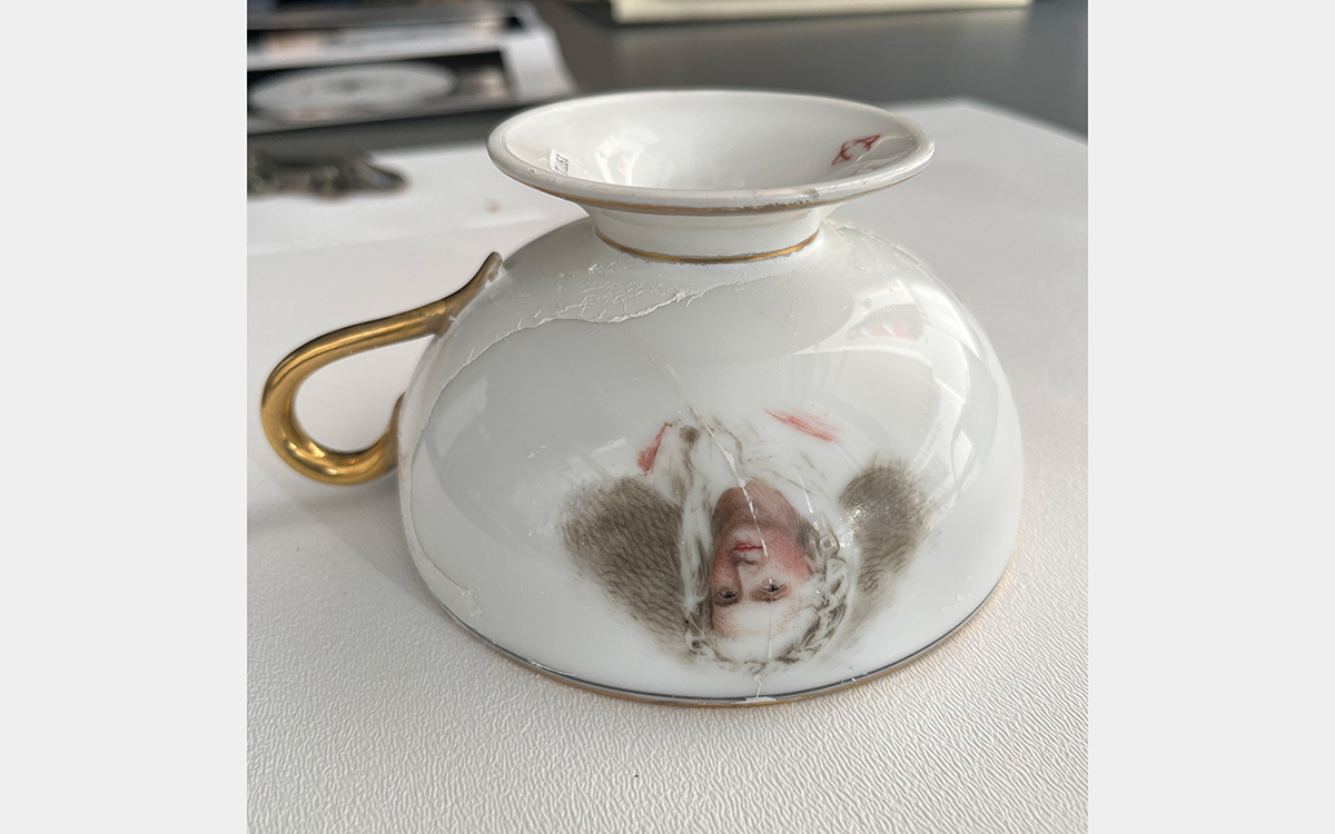 Upside down teacup with a painted portrait of a man.