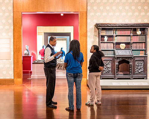 A gallery attendant talks to two visitors