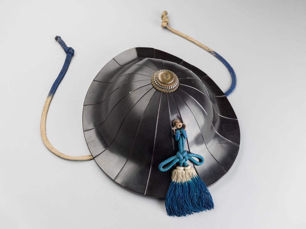 A traditional conical hat featuring a primarily black outer shell embellished with multiple straight lines.