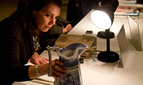 curator inspecting a pitcher