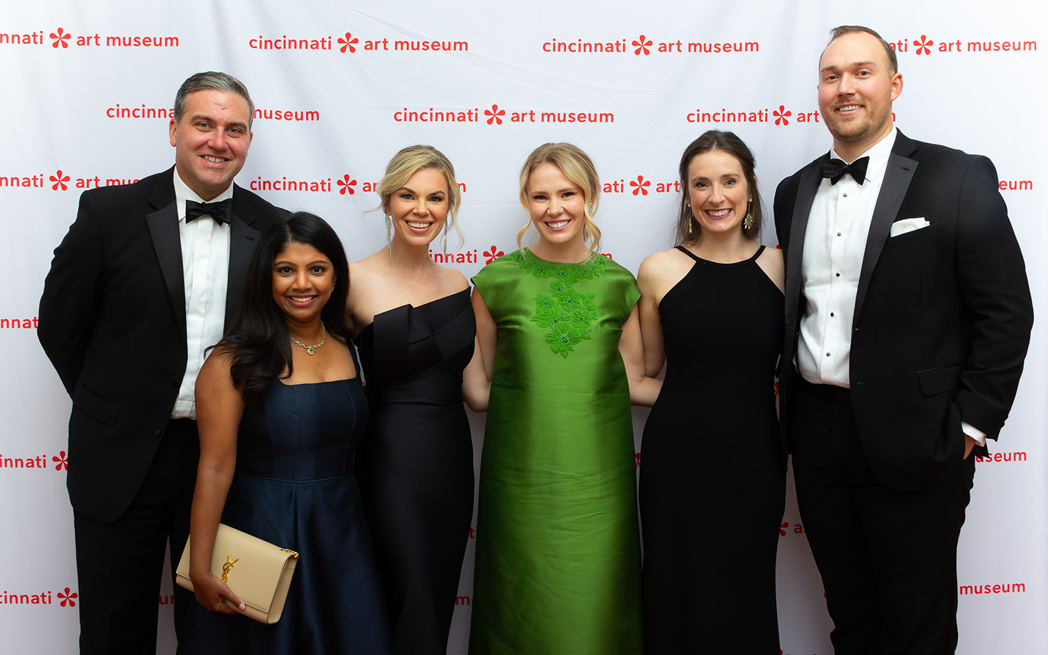 A group of well dressed people smile for a picture