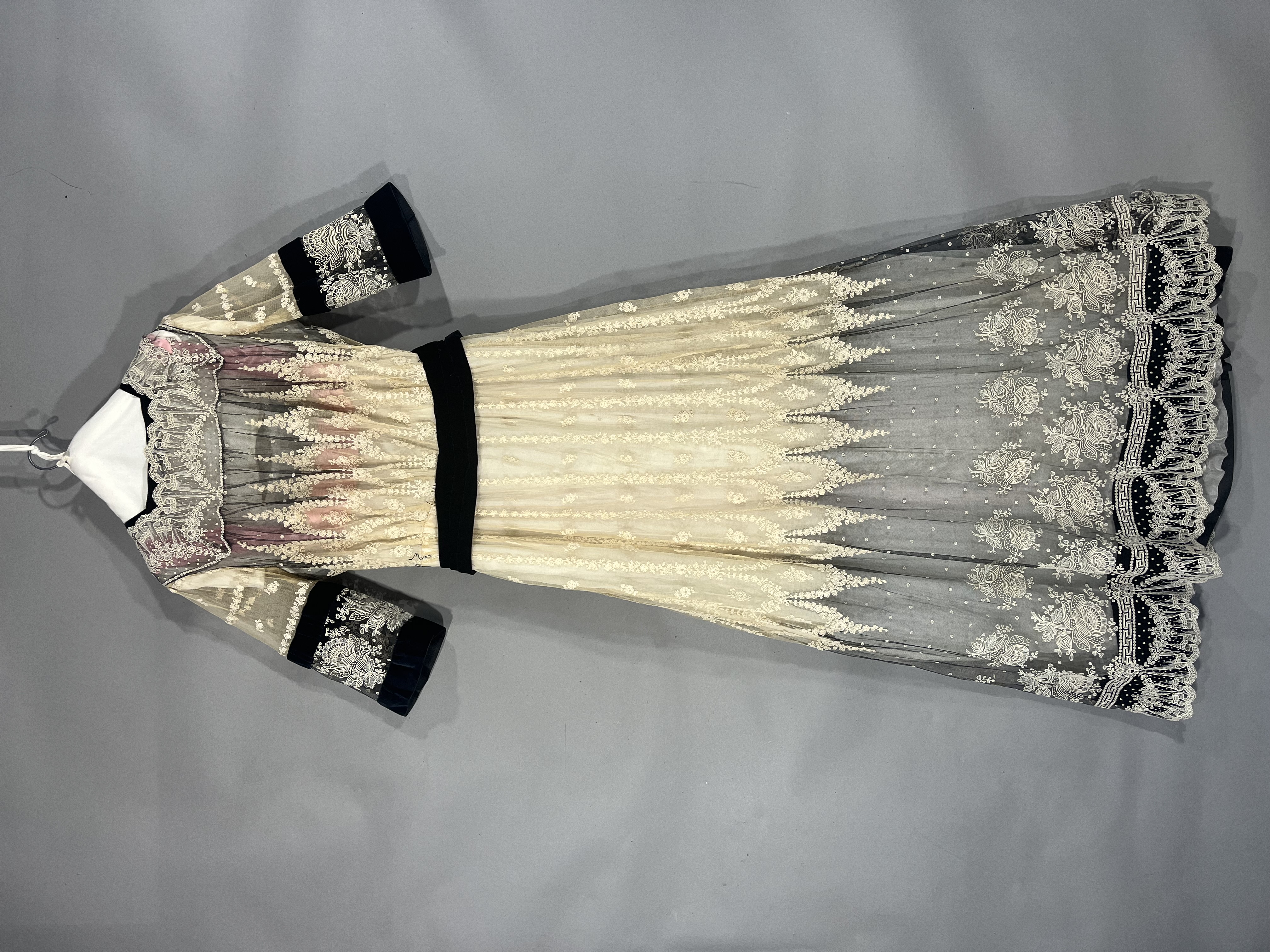 Long dress with elbow length sleeves and black waist sash.