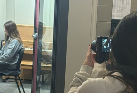 A student takes a picture of another student in a room studying