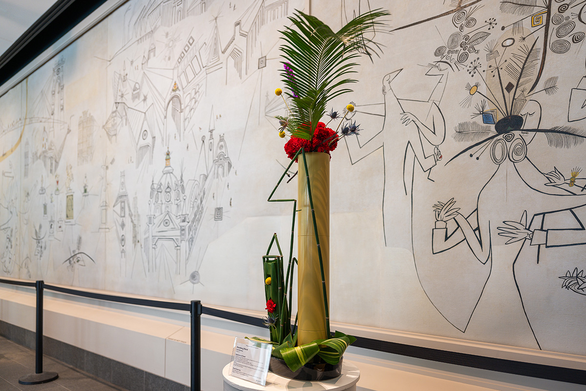 A tall arrangement with a thin bamboo form in the shape of a person