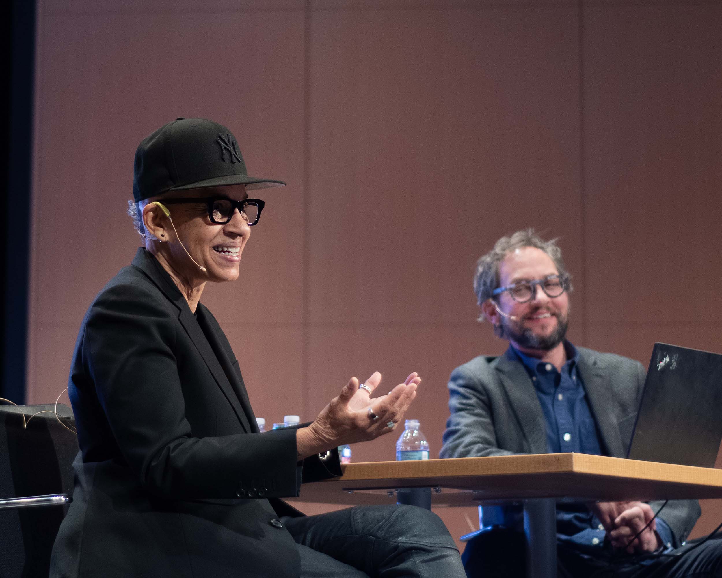 A smiling Black person speaks onstage