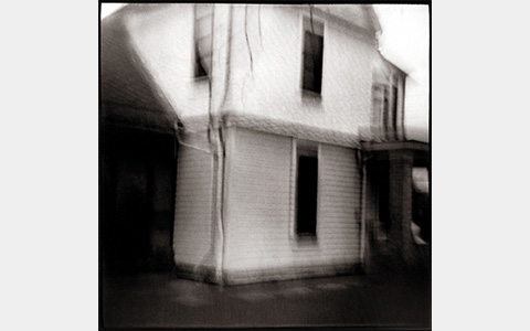 Nancy Rexroth's Waving House, a blurry black and white photograph of a simple, two story house 