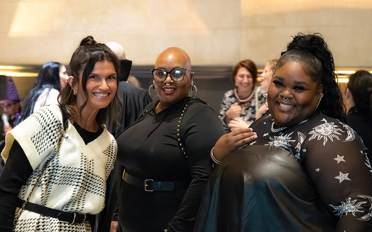 Three women smile at the camera