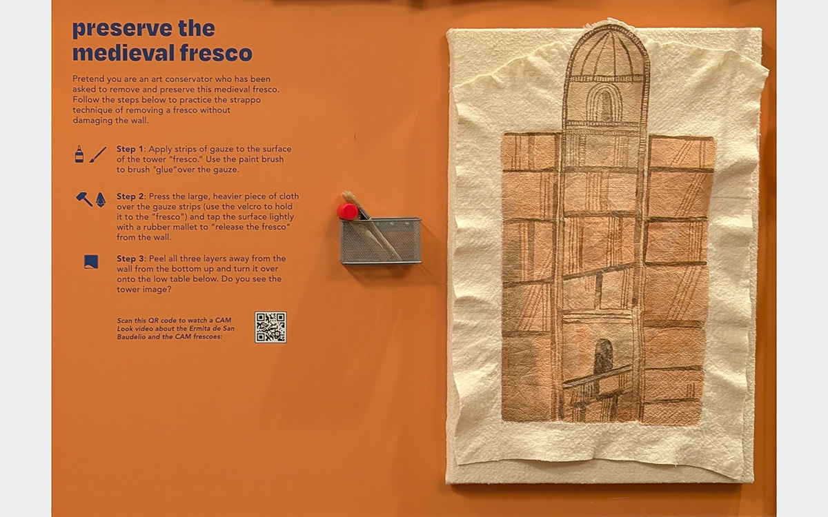 Wall with written instructions for an activity with a tower image and kid-made artwork framing the wall.