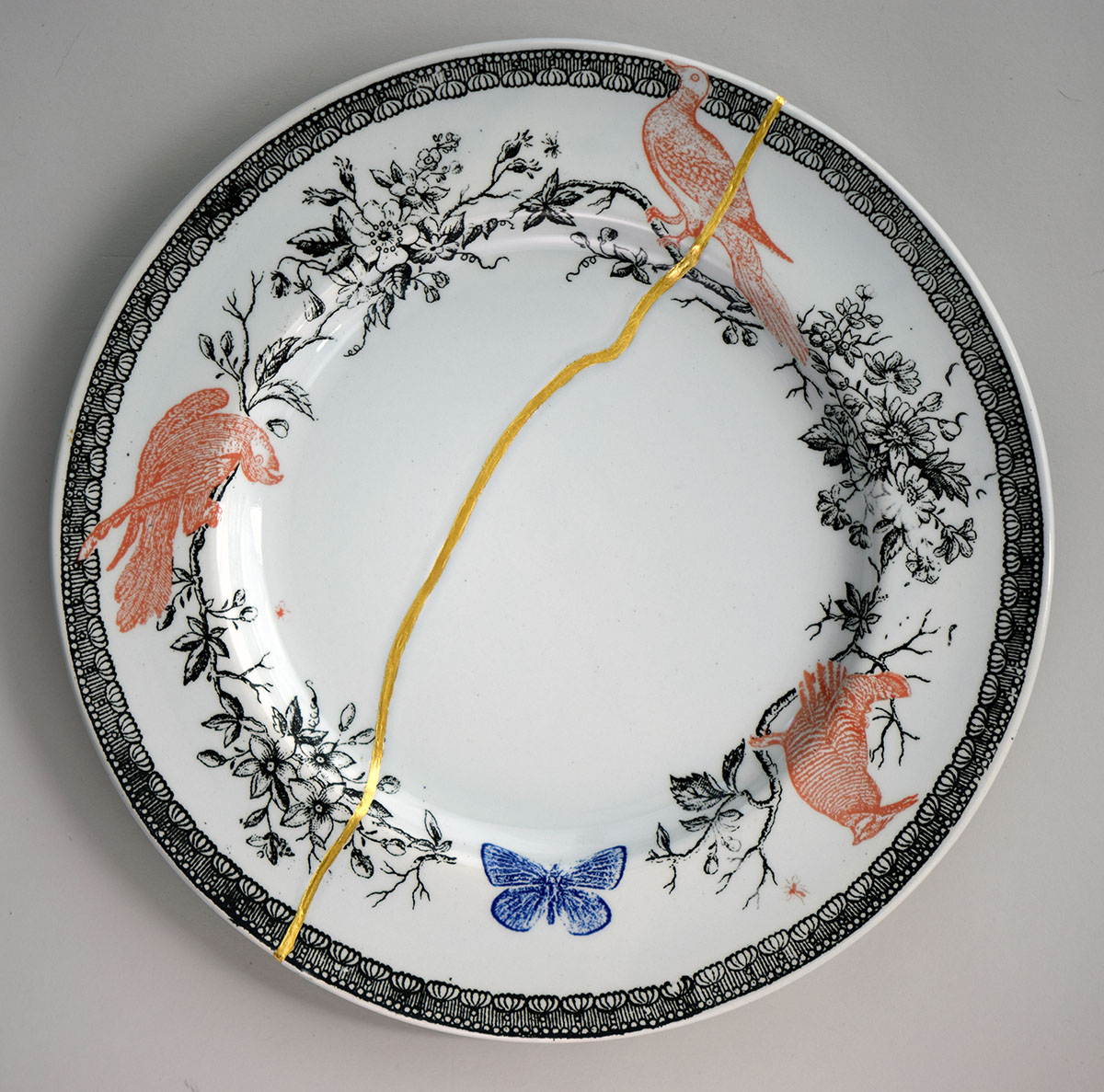 A broken white plate repaired with gold