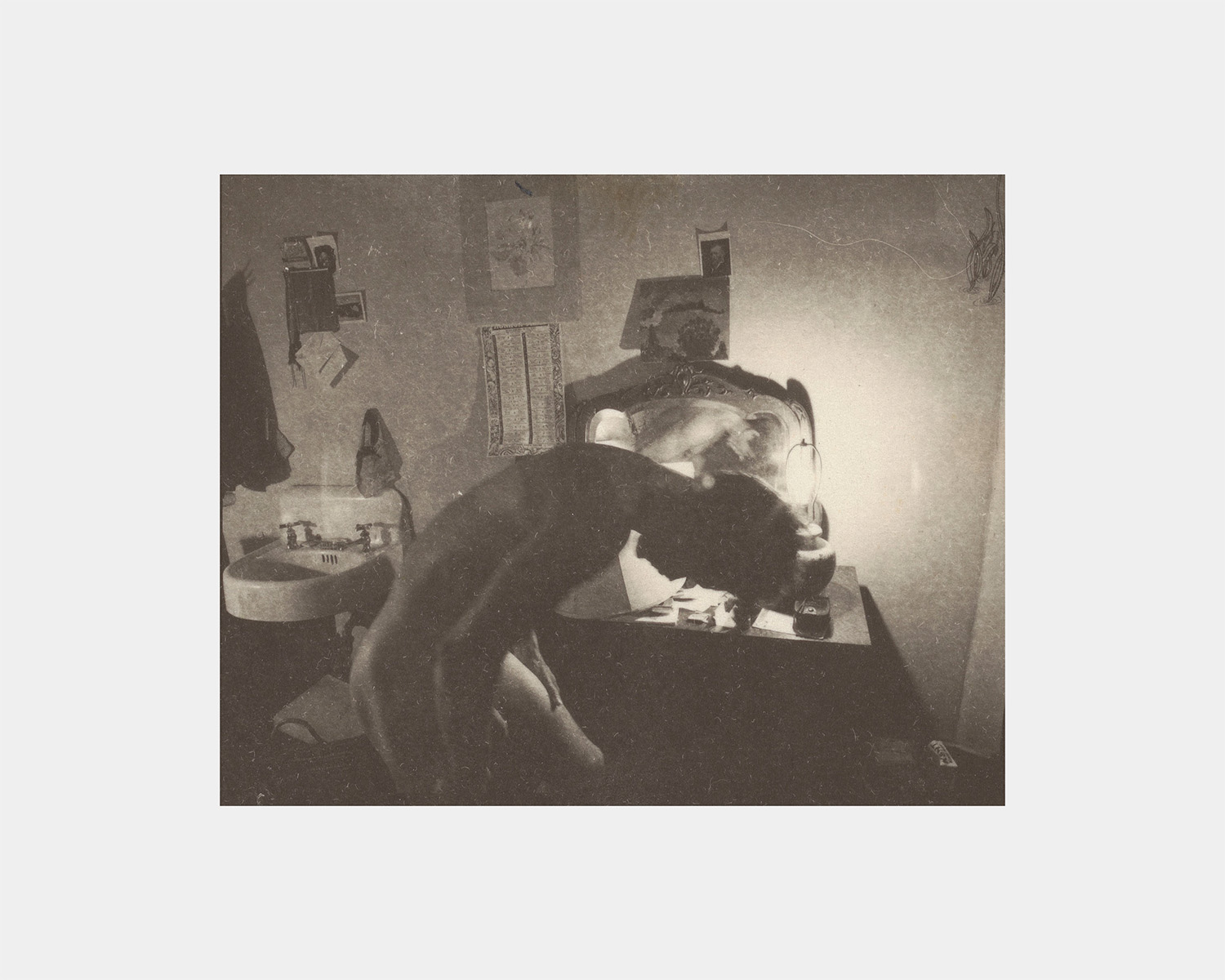 A black and white photo of a white man in an apartment