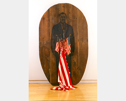 An illustration of a man wearing a suit on dark wood. Several small American flags sit in front, including one large one draped on the floor.