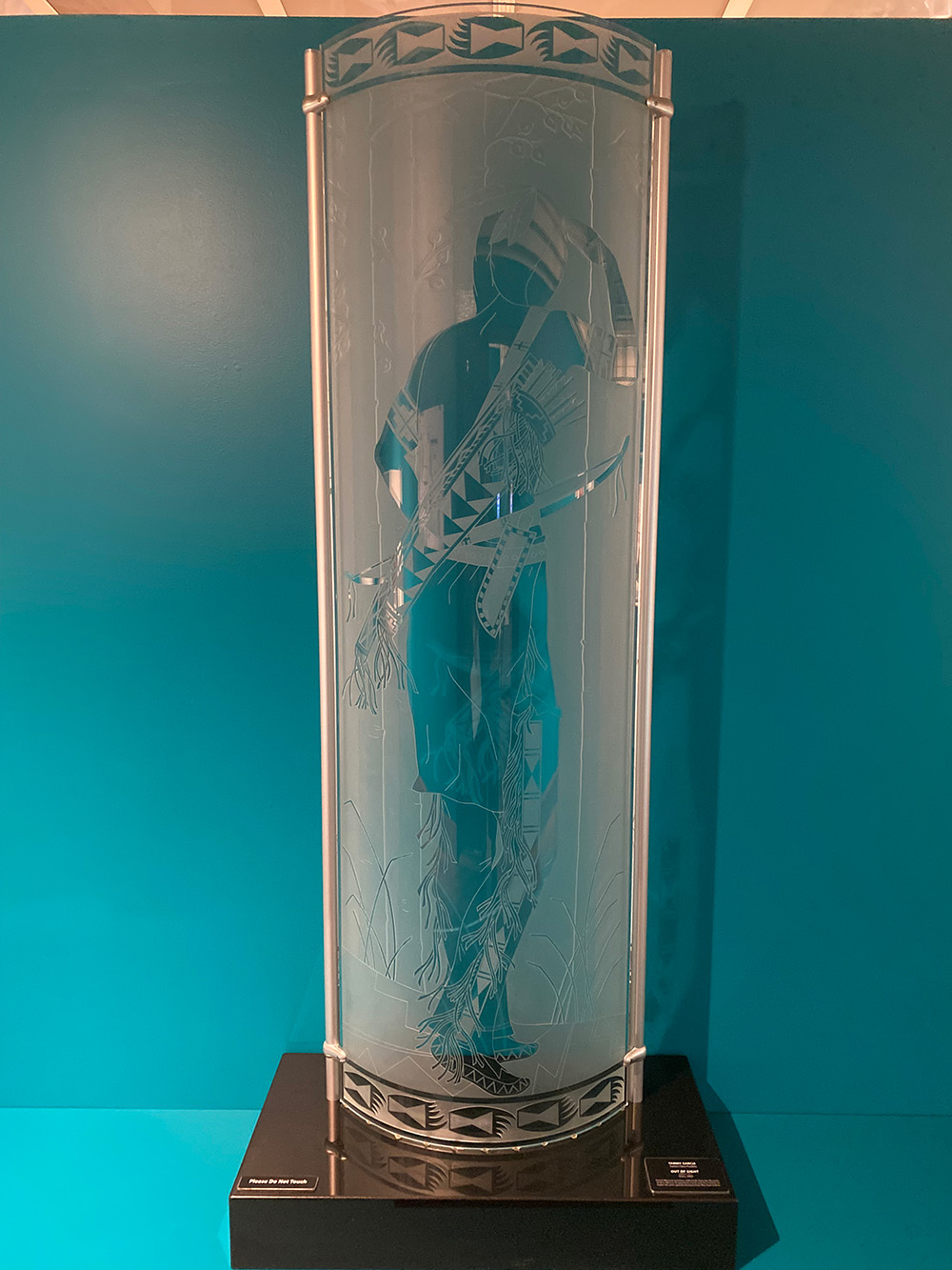 A tall glass curved panel with a person's silhouette