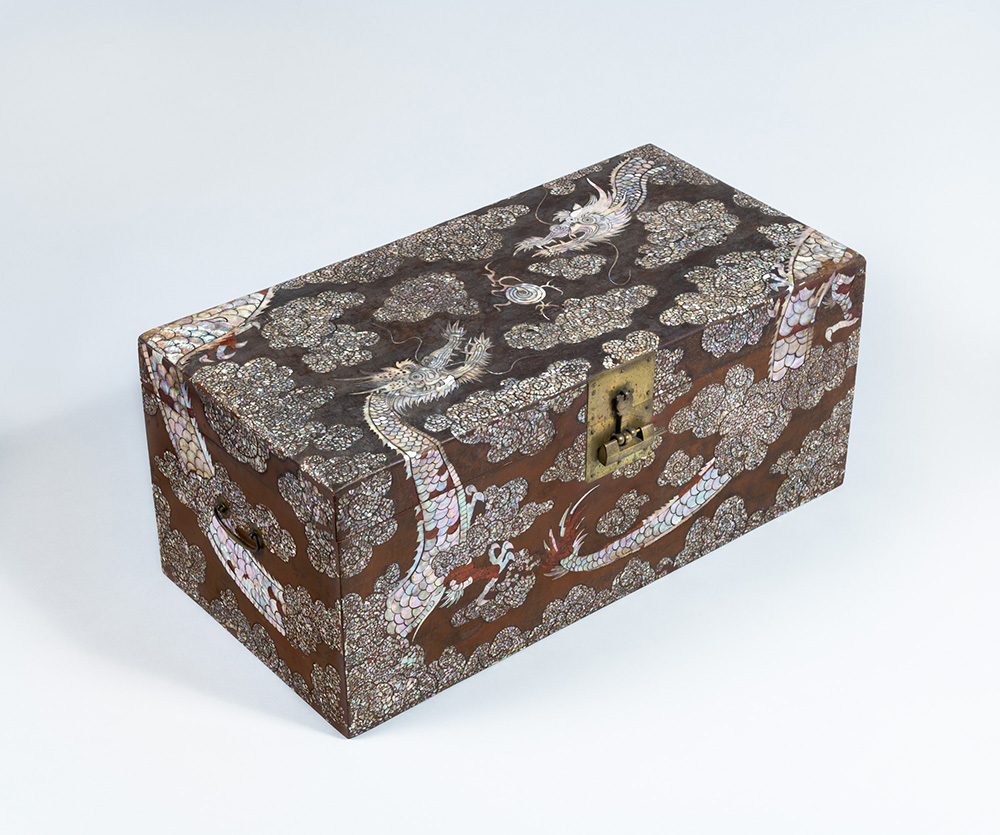 A brown chest covered with inlays depicting two dragons in the clouds