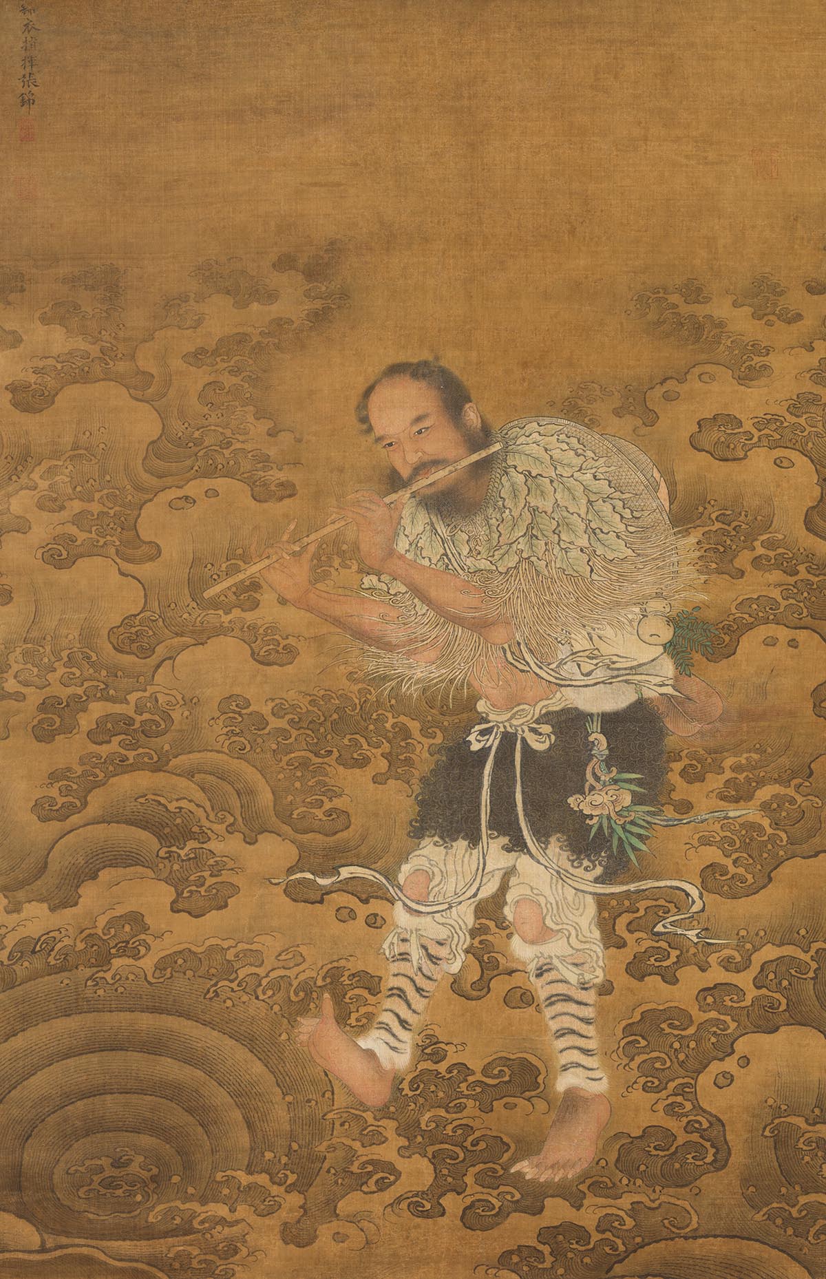 A man playing a flute walks through waves.