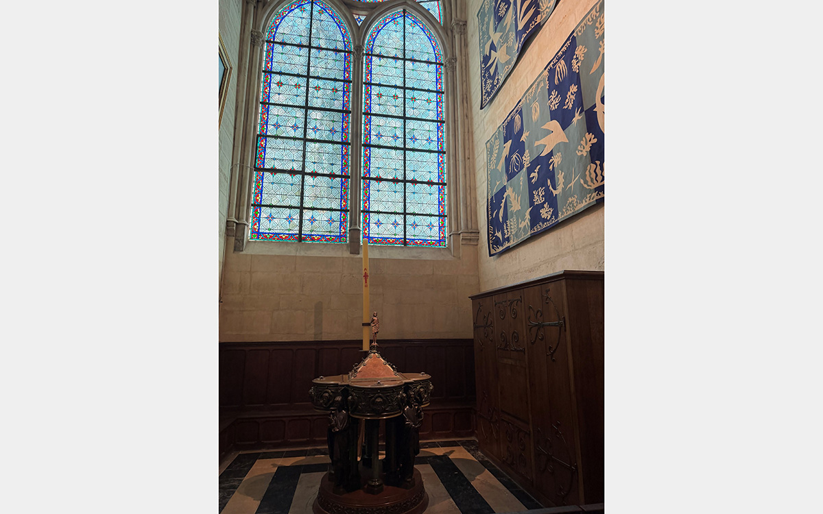 Stained glass and tapestries inside a church baptistry