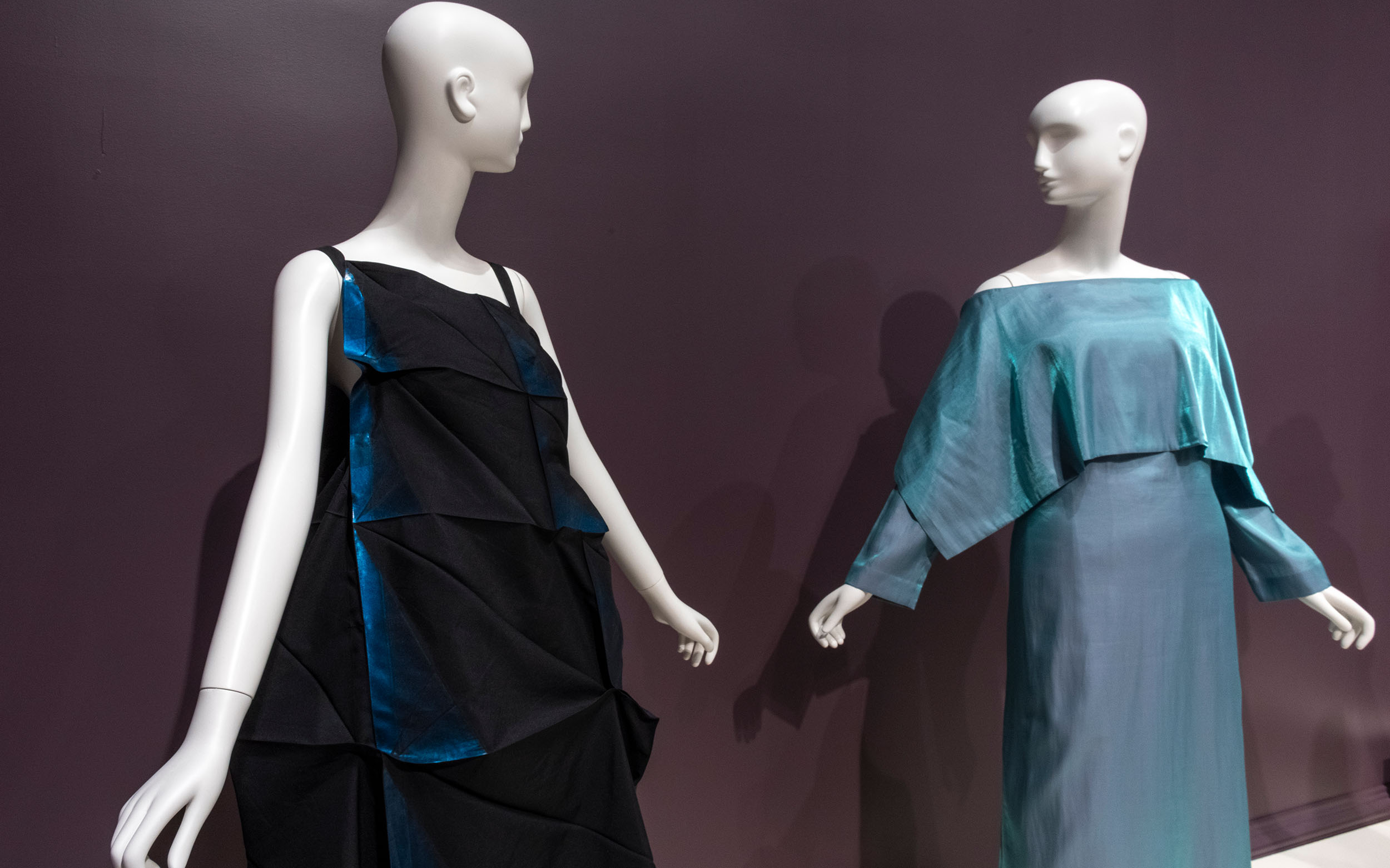 Two mannequins wearing dresses face each other