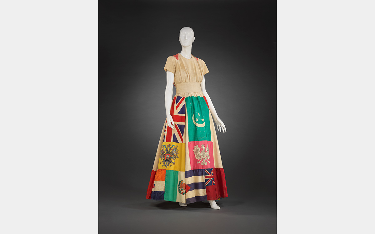 White mannequin wearing a dress featuring international flags on the skirt