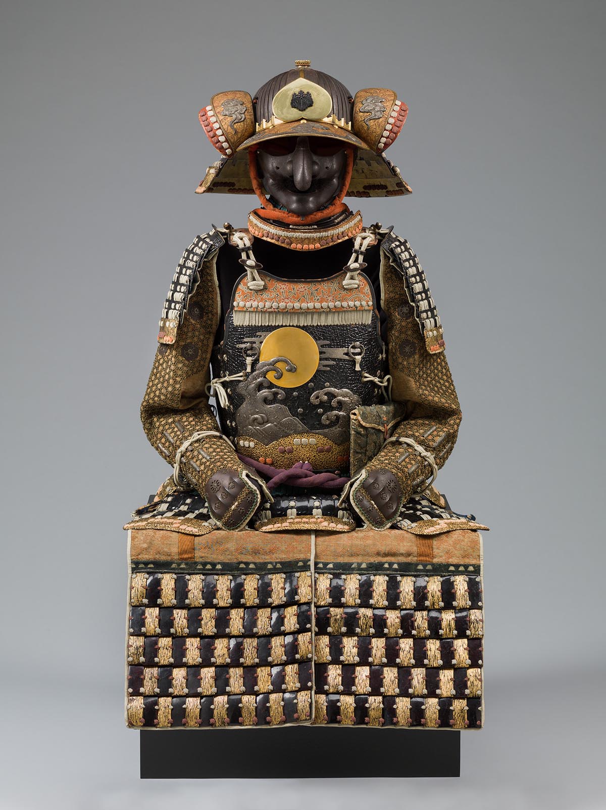 An ornate suit of armor with a sunlit wave design on the chest.