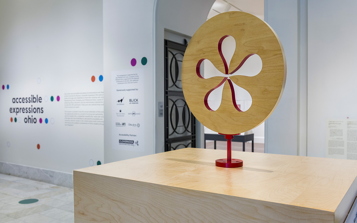 A wooden circle with an asterisk cut out of the center on the top of the cart