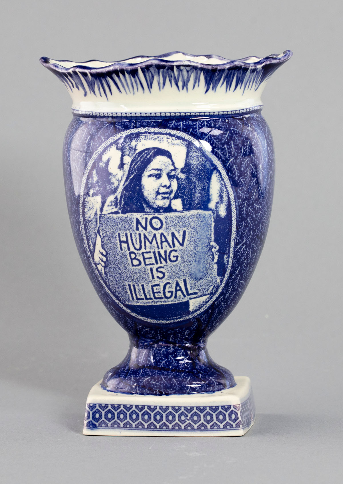 A blue and white vase with a picture of a person.