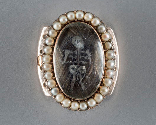 Brooch featuring an engraved skeleton surrounded by pearls
